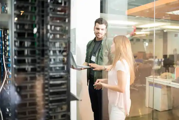 New Office IT Setup two business people standing server room with laptop discussing 1